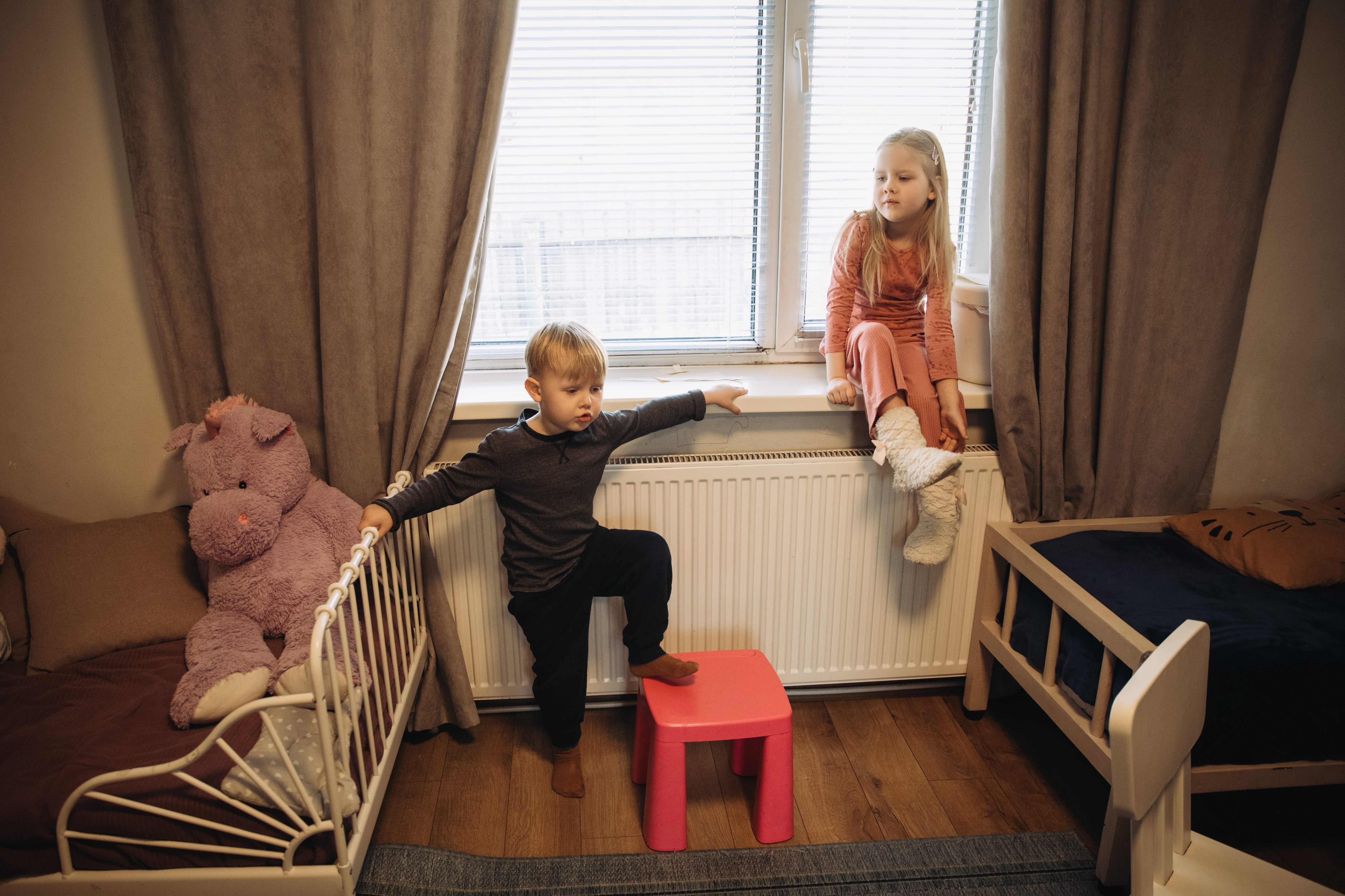 zwei kinder auf einem fensterbrett sitzend